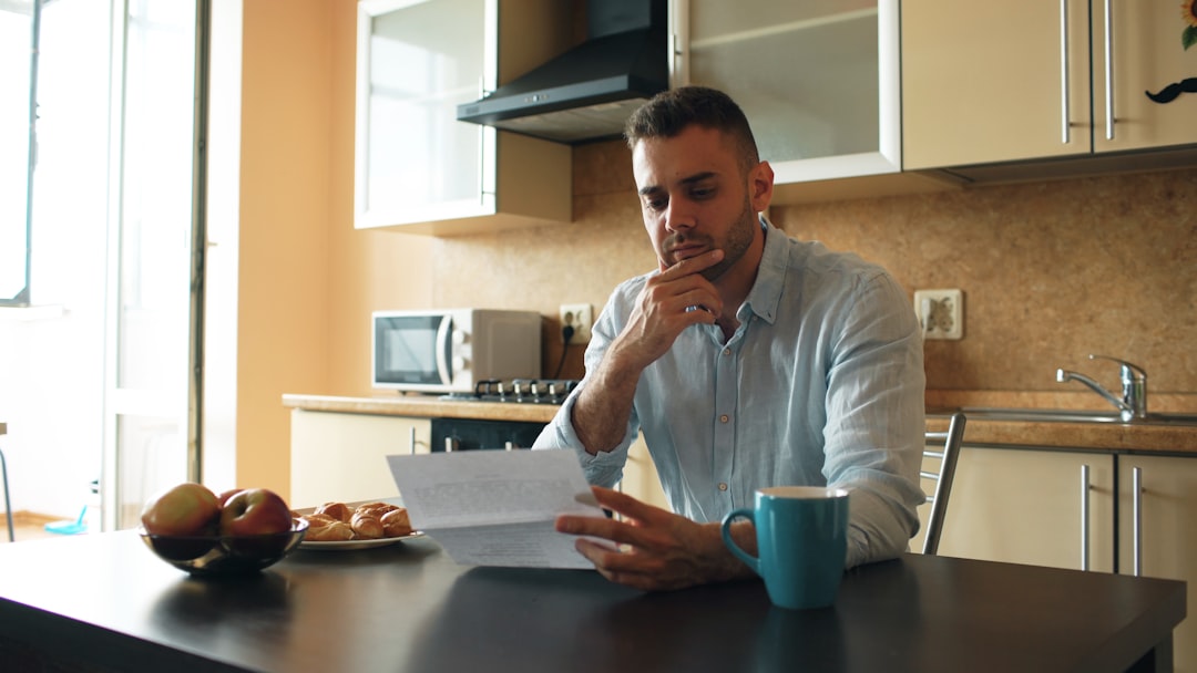 Man reading a document in a kitchen - Photo by Vitaly Gariev on Unsplash