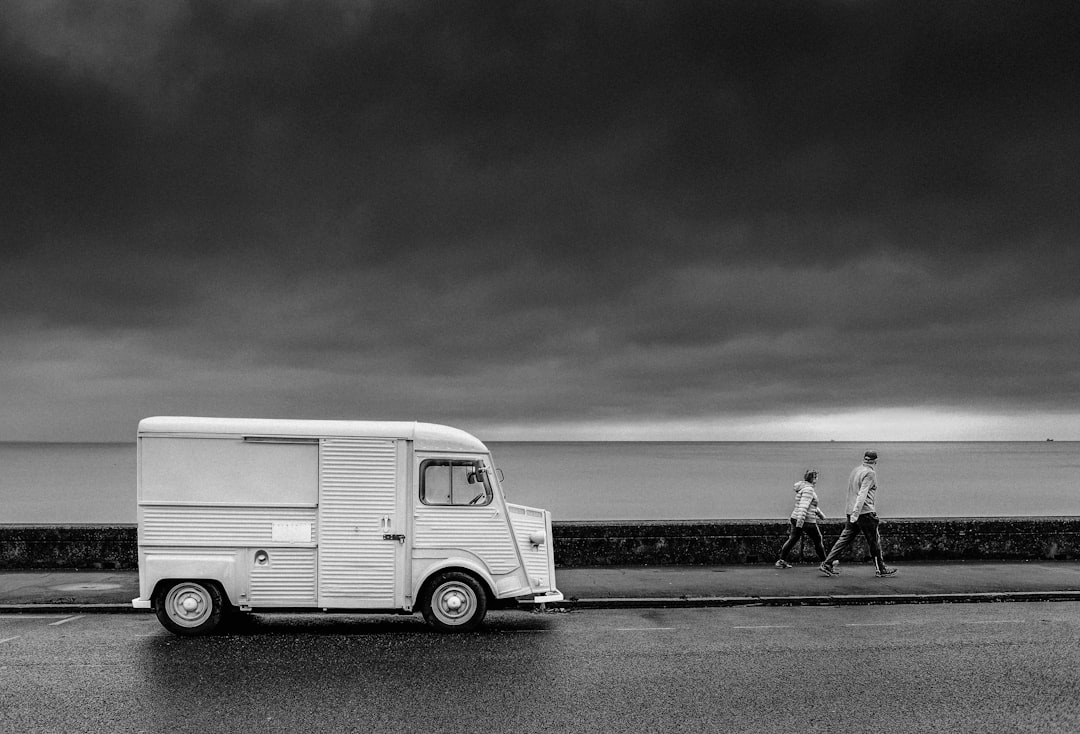 grayscale photo of man and woman walking on beach - Photo by Zoltan Tasi on Unsplash