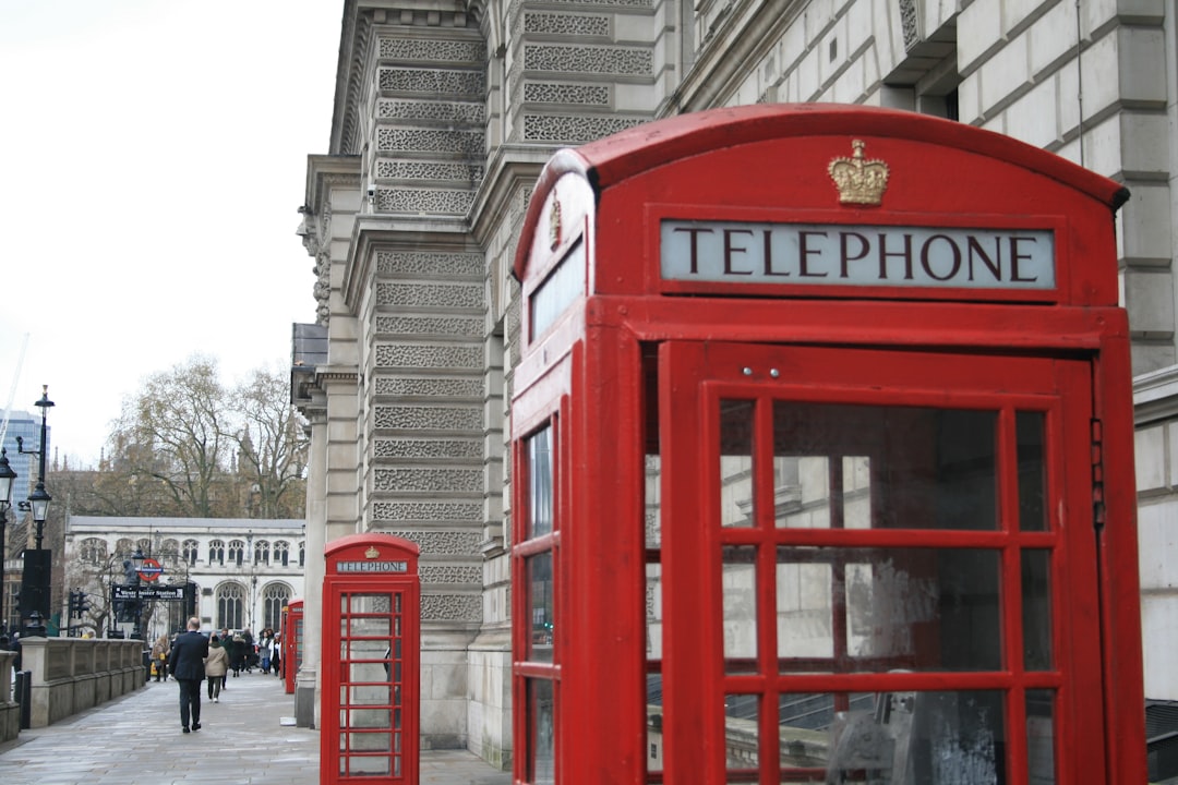 a red telephone booth sitting on the side of a street - Photo by Paul Cariou on Unsplash