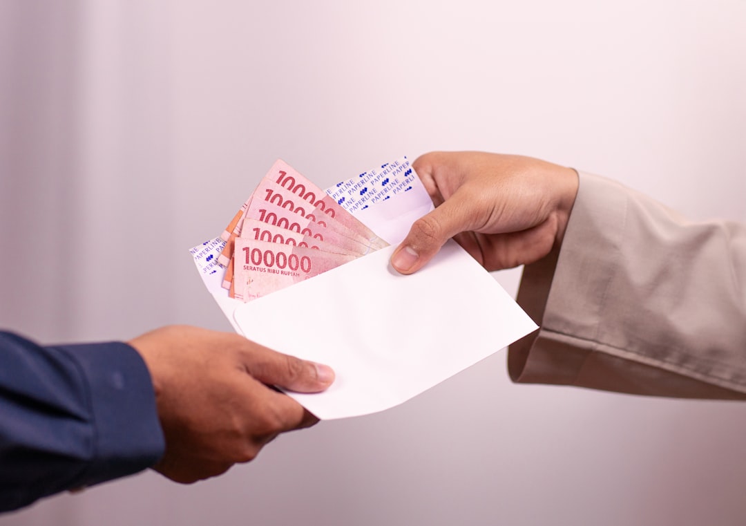 Money is being handed over between two people. — Photo by Defrino Maasy on Unsplash