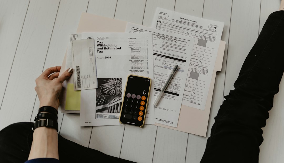 person holding paper near pen and calculator - Photo by Kelly Sikkema on Unsplash
