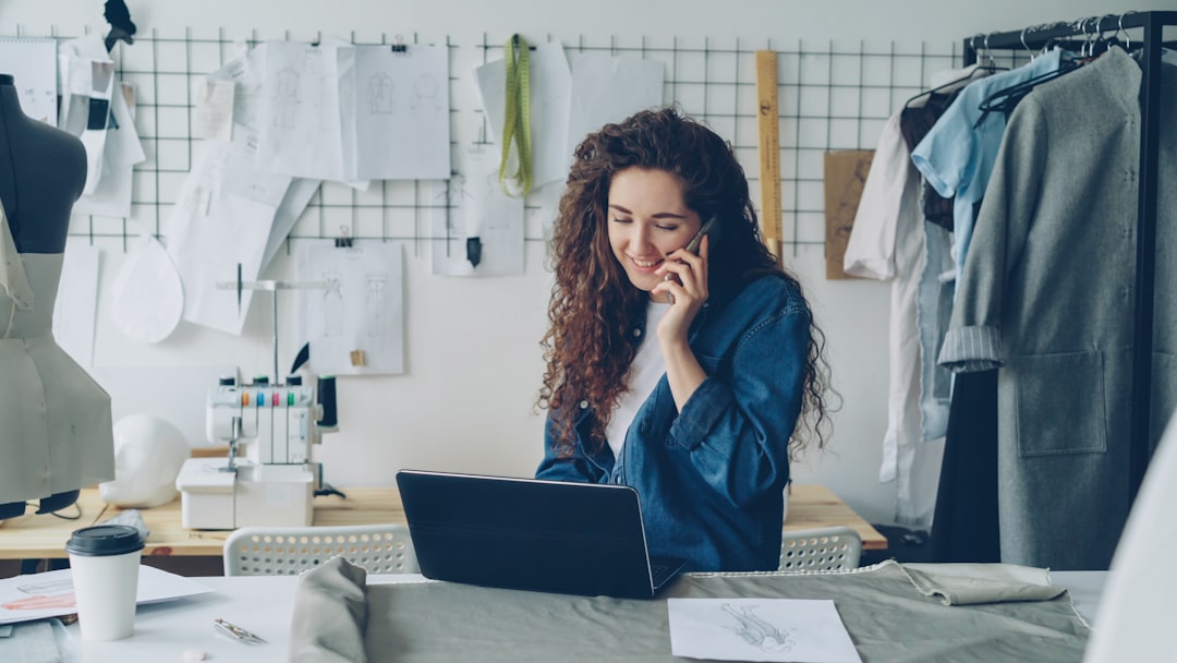 Fashion designer on the phone, working on a laptop. - Photo by Vitaly Gariev on Unsplash