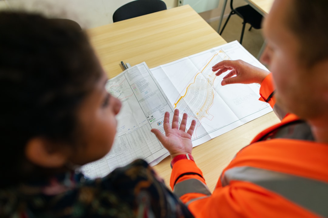 boy in orange long sleeve shirt writing on white paper - Photo by ThisisEngineering on Unsplash