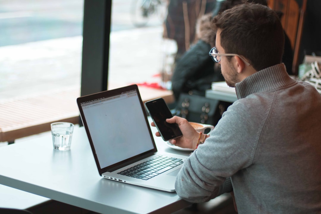 man sitting near table with laptop and smartphone near window - Photo by Joseph Frank on Unsplash