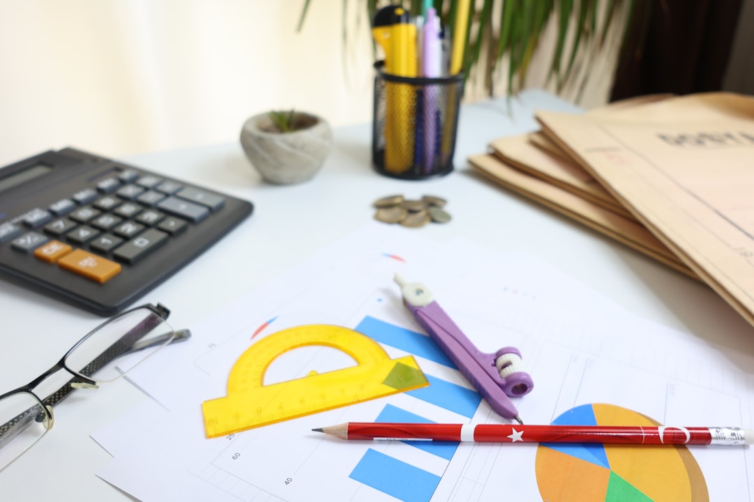 Desk with calculator, glasses, and drawing tools - Photo by Cht Gsml on Unsplash