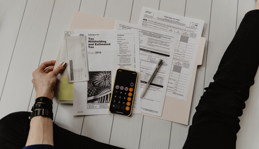 person holding paper near pen and calculator - Photo by Kelly Sikkema on Unsplash