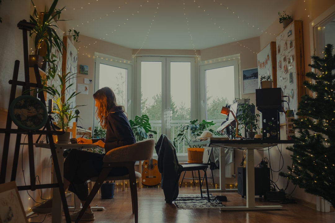 Woman working at a desk in a cozy, plant-filled room. — Photo by Hanna Lazar on Unsplash