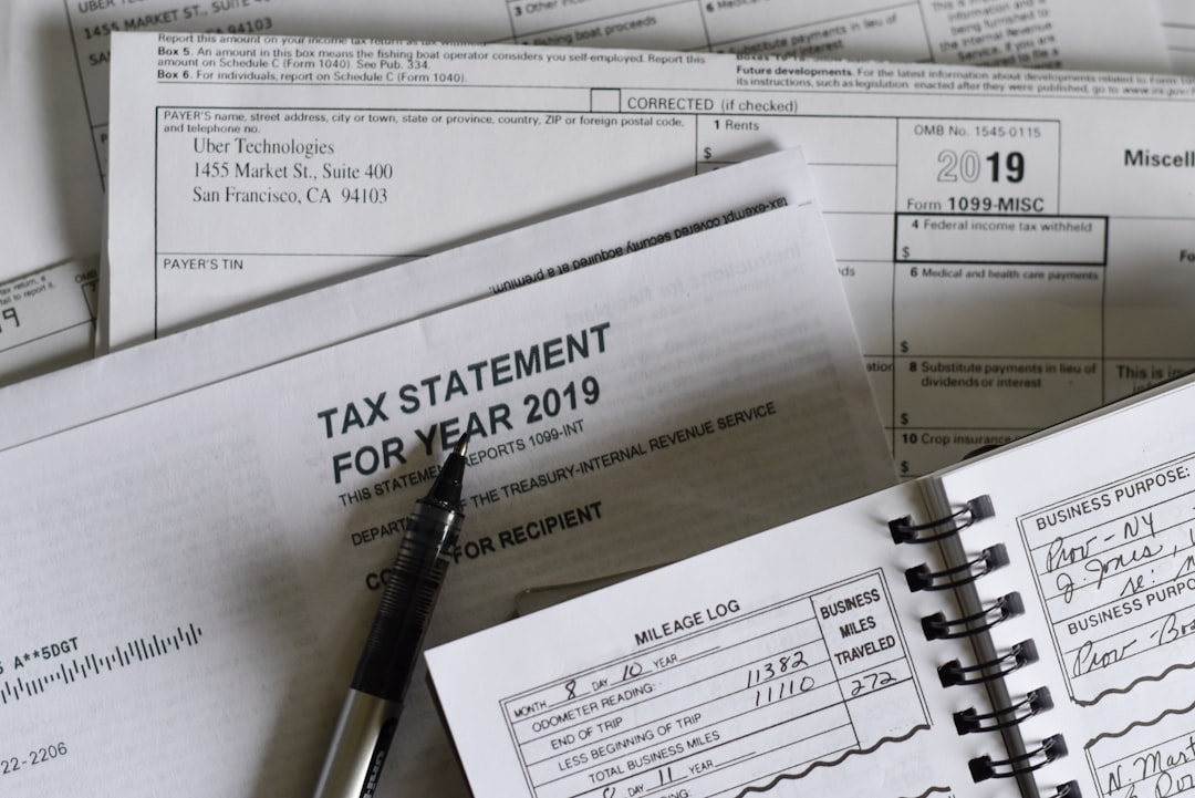 A pen resting on 2019 tax forms and a mileage log book - Photo by Olga DeLawrence on Unsplash