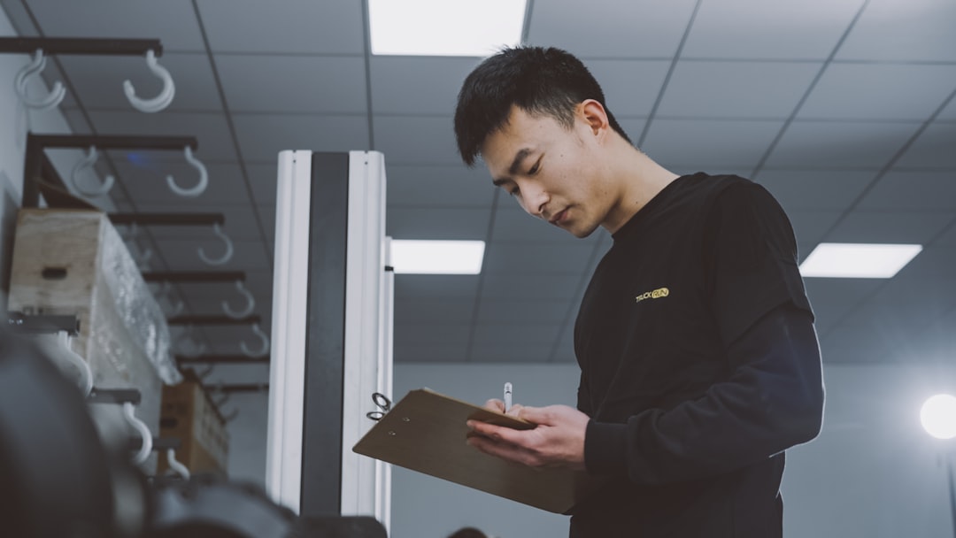 a man standing in a room holding a clipboard - Photo by TruckRun on Unsplash