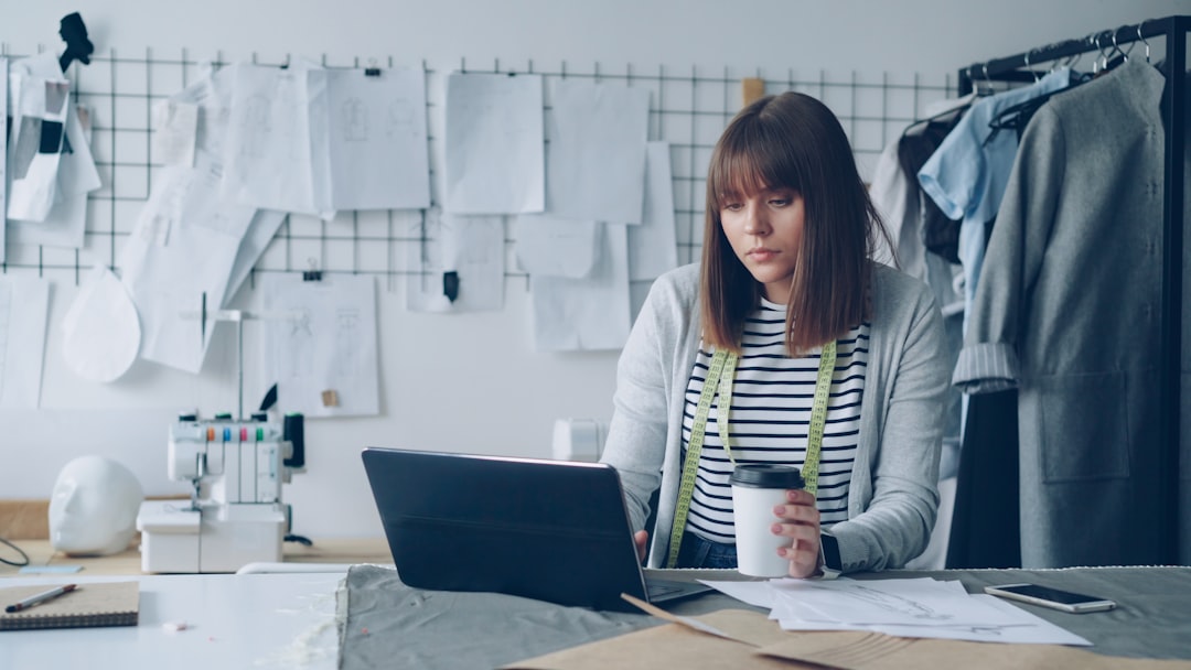 Fashion designer working on her laptop and sipping coffee. - Photo by Vitaly Gariev on Unsplash