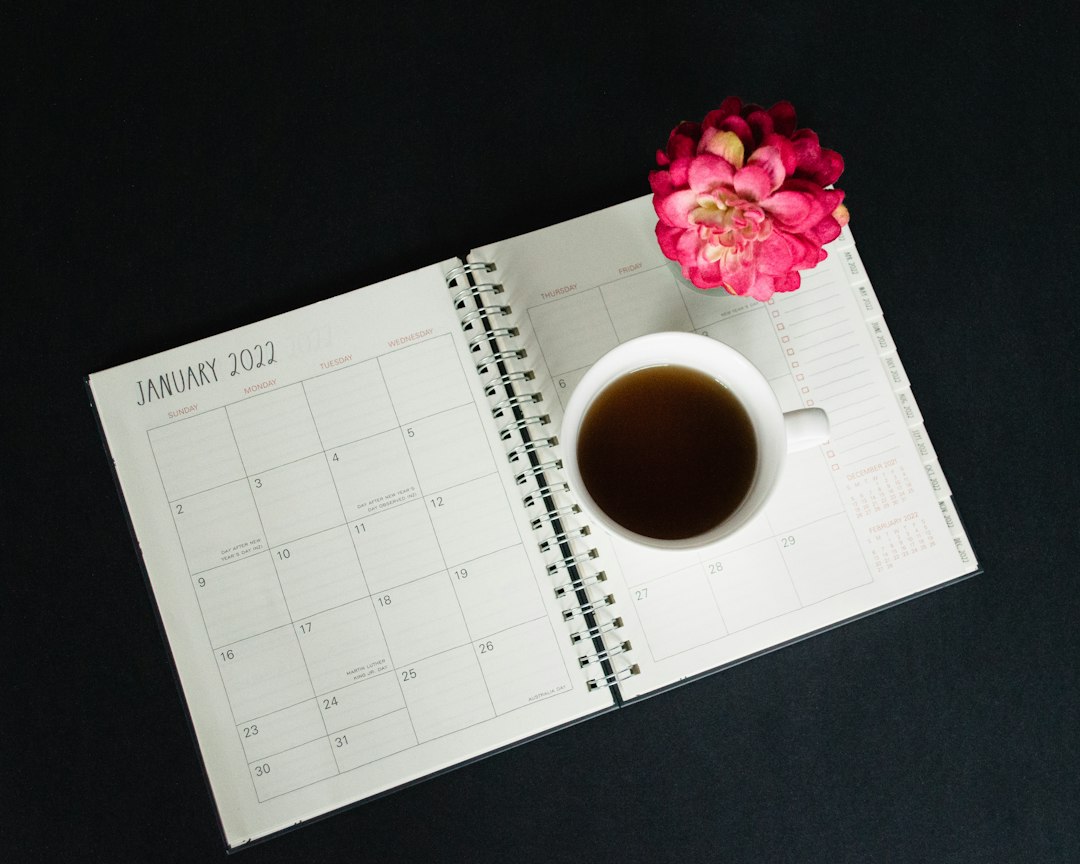 a cup of coffee sitting on top of a desk next to a calendar - Photo by Debby Hudson on Unsplash