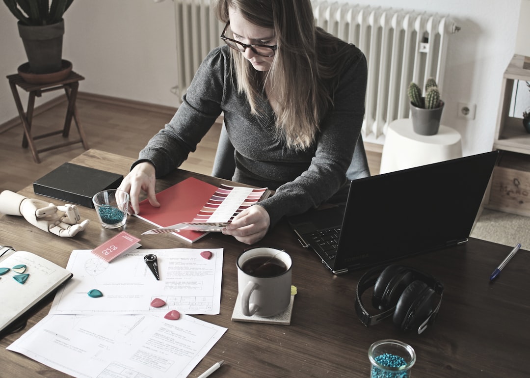 woman in gray long sleeve shirt sitting at the table - Photo by Rombo on Unsplash