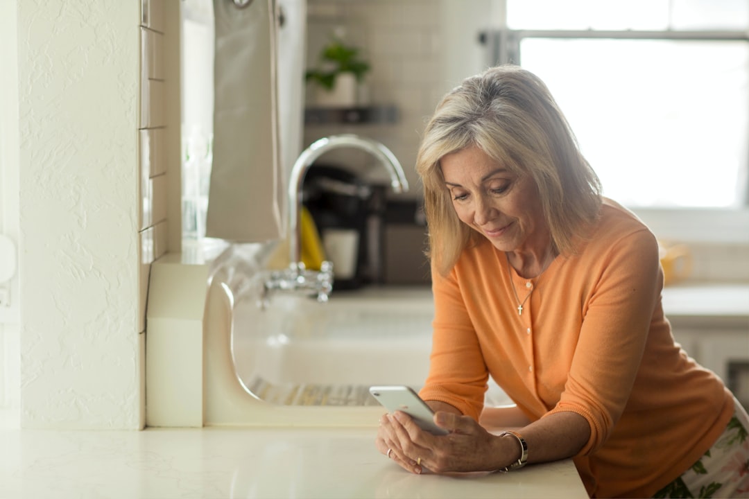 woman in orange long sleeve shirt using white smartphone — Photo by YouVersion on Unsplash