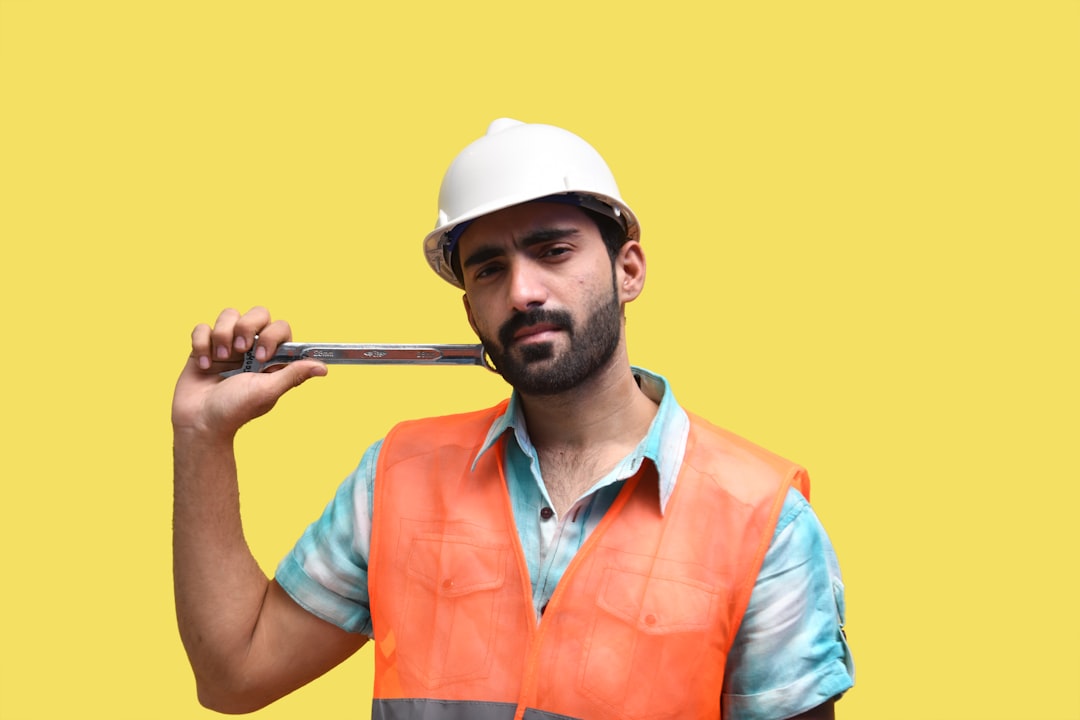 a man wearing a hard hat and holding a gun - Photo by Fotos on Unsplash