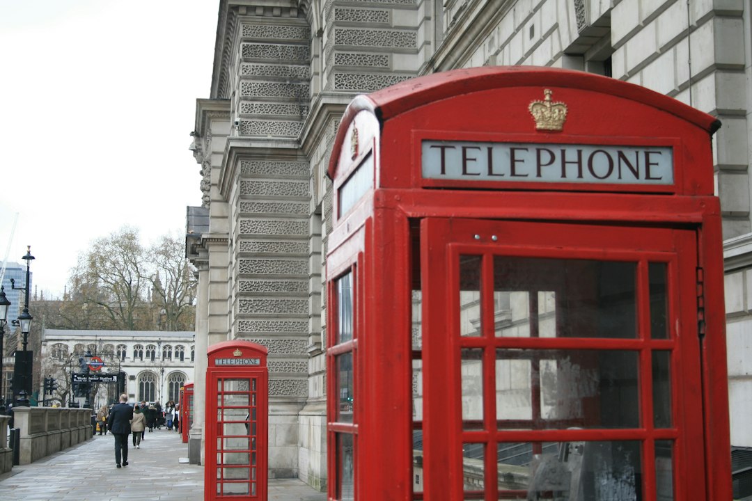 a red telephone booth sitting on the side of a street - Photo by Paul Cariou on Unsplash