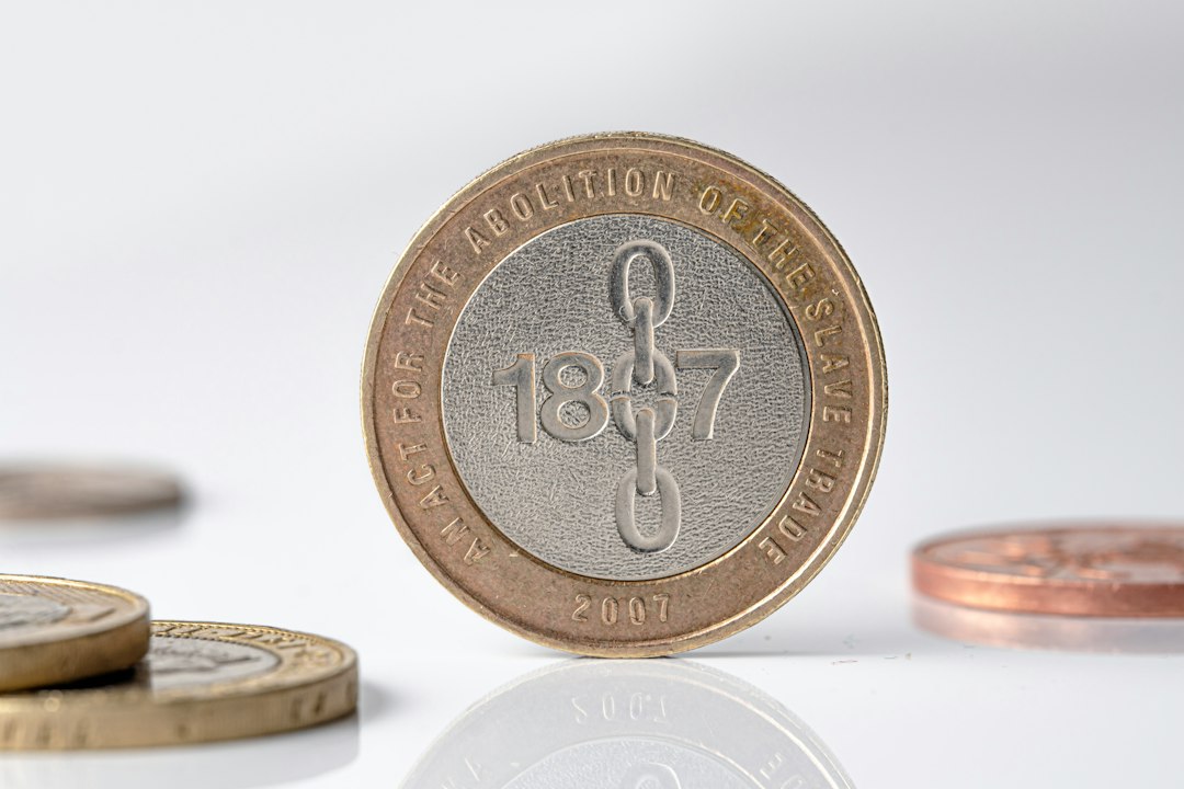 Two-pound coin with '1807' and a broken chain design - Photo by Mohamed Marey on Unsplash