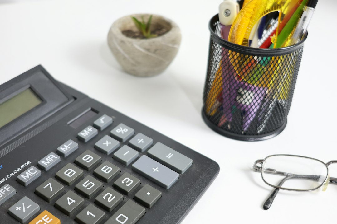 Calculator, glasses, and pens on a white desk - Photo by Cht Gsml on Unsplash
