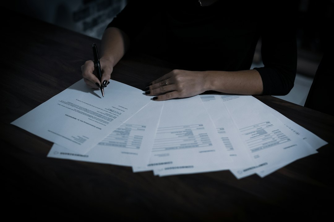 a woman sitting at a table with lots of papers - Photo by Dimitri Karastelev on Unsplash
